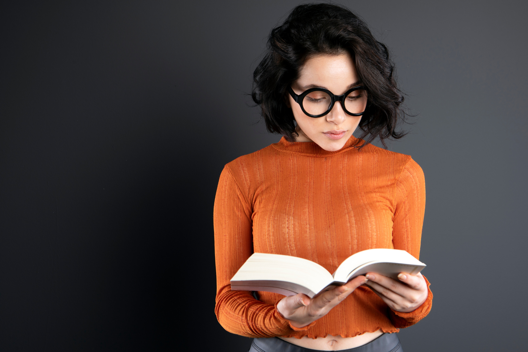 Woman in an orange top reading a book