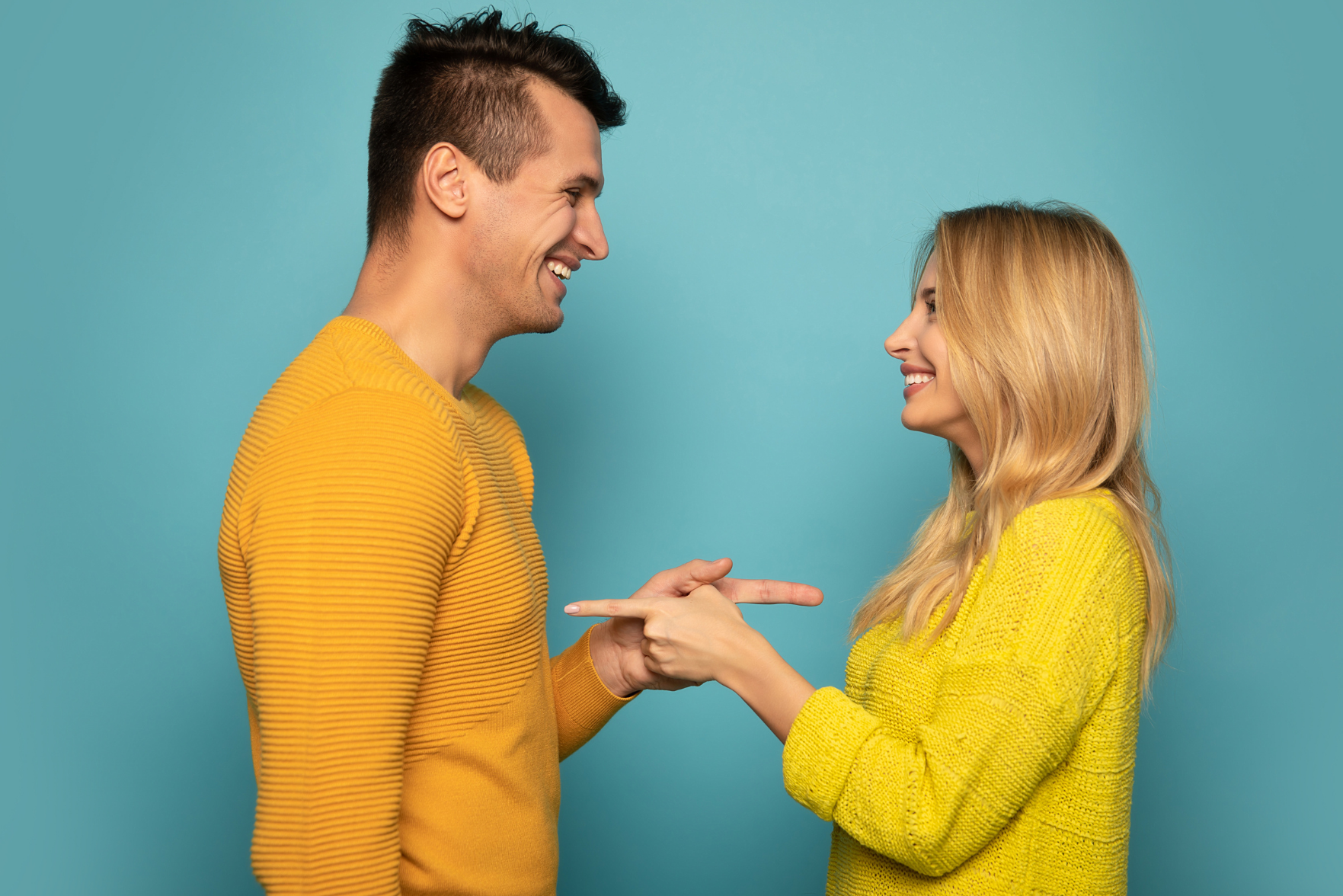 Man and woman pointing at one another