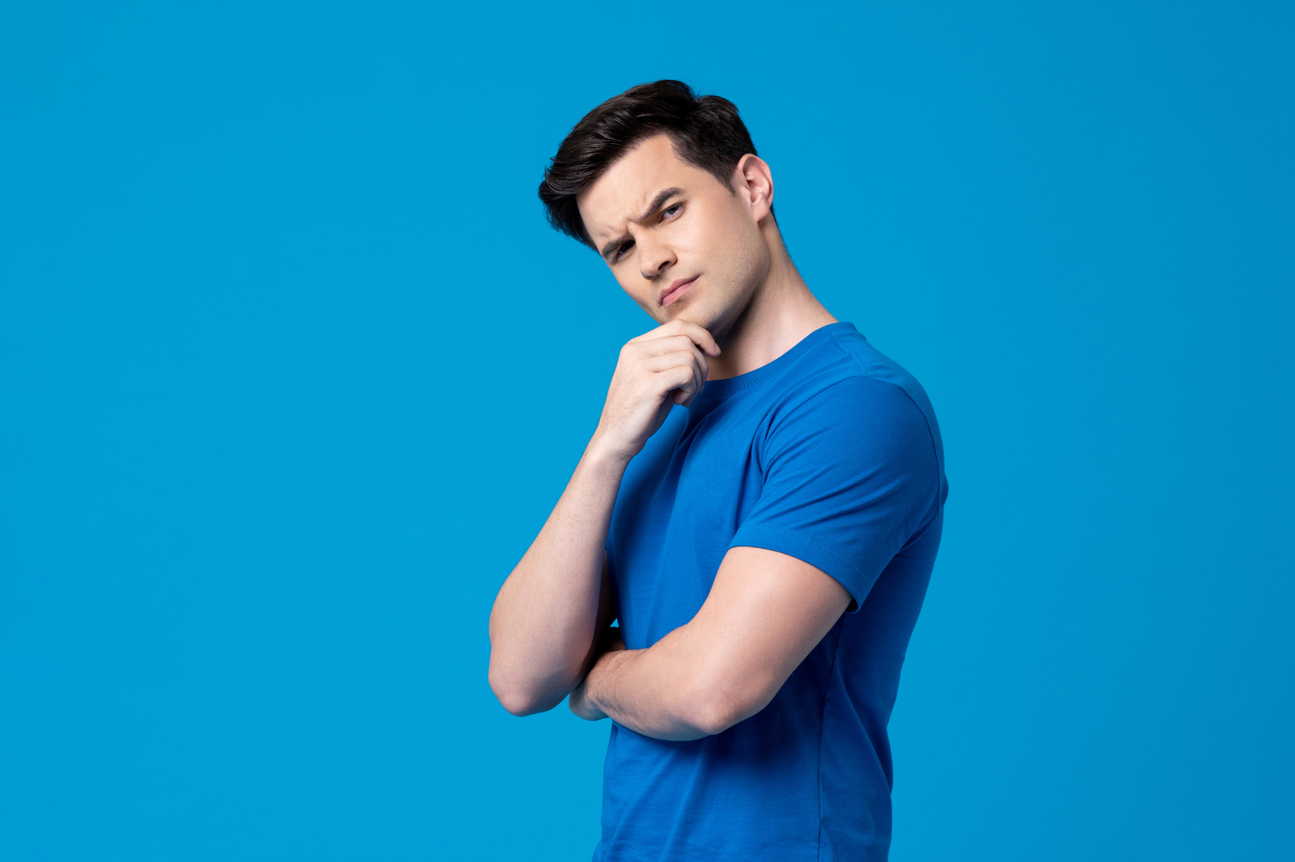 Pensive young man against a blue background