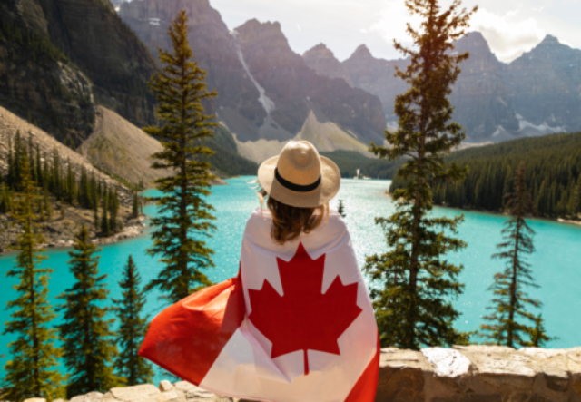 Woman observing a Great Lake draped in a Canadian flag